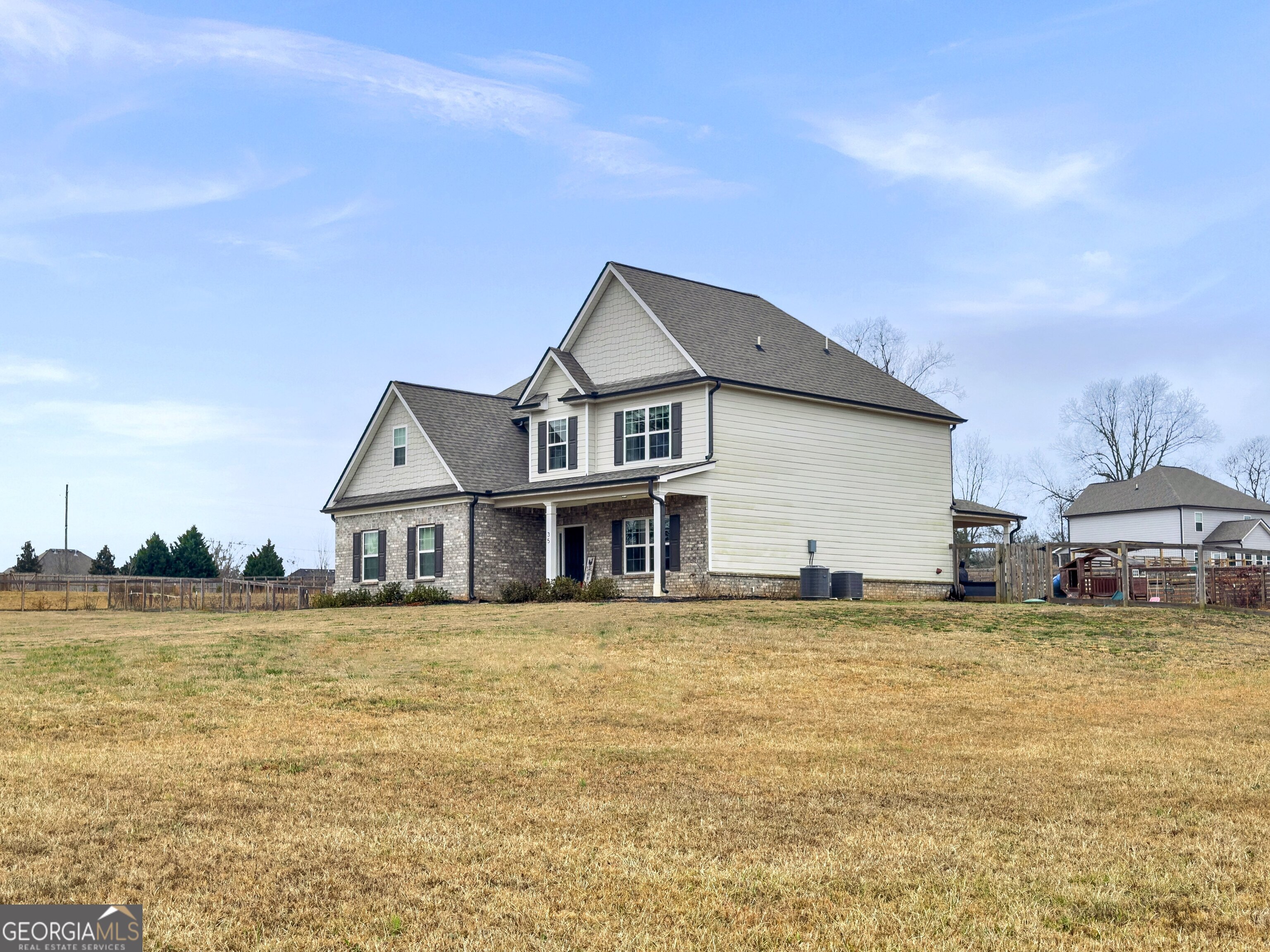 35 Sandy Ridge Road McDonough, GA 30252 - Photo 15 of 63 a white house with a large pool and lawn chairs under an umbrella