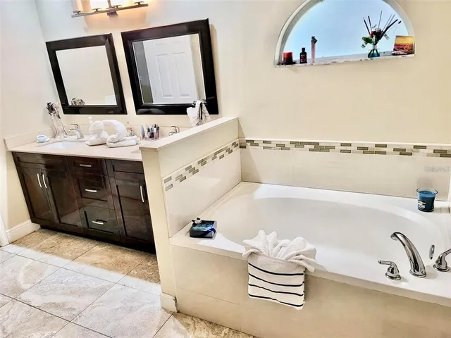 a bathroom with a bathtub sink and mirror
