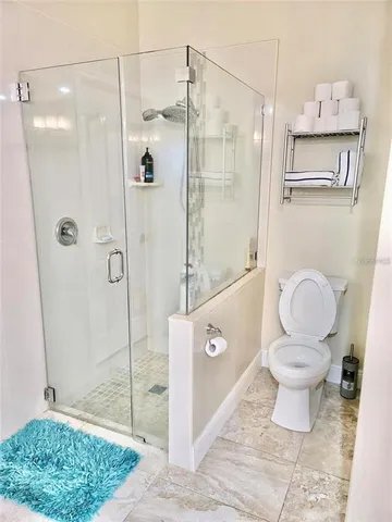 a bathroom with a granite countertop sink a toilet and shower