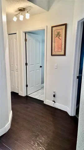 a view of an empty room with wooden floor