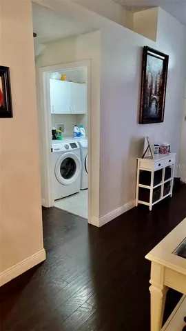 a view of a hallway with wooden floor and cabinet