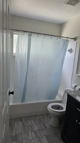 a white toilet sitting next to a shower