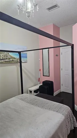 a bedroom with a bed window and a chandelier