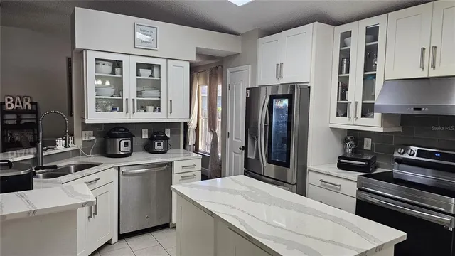 a kitchen with stainless steel appliances granite countertop a refrigerator stove and sink
