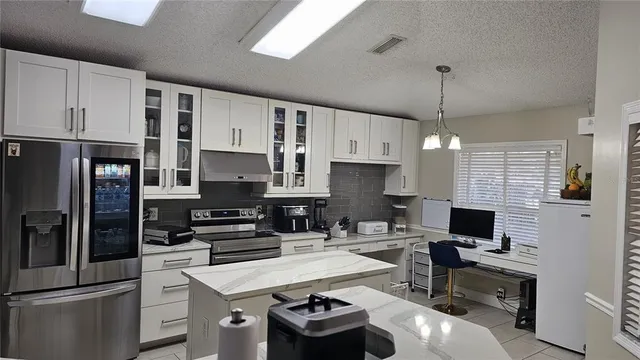 a kitchen with stainless steel appliances a stove sink and refrigerator
