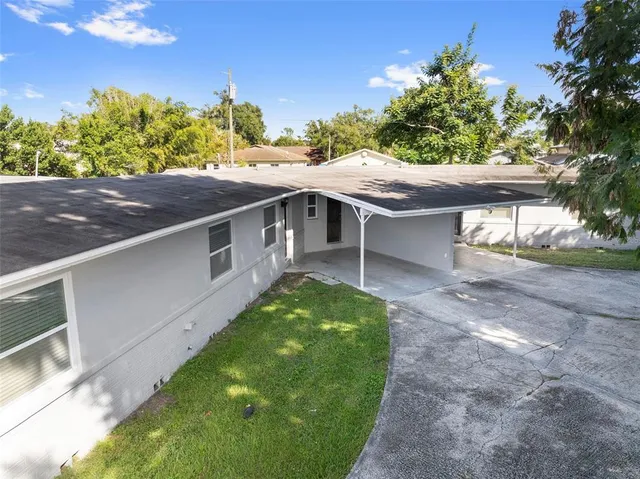 a view of a house with a patio and a yard