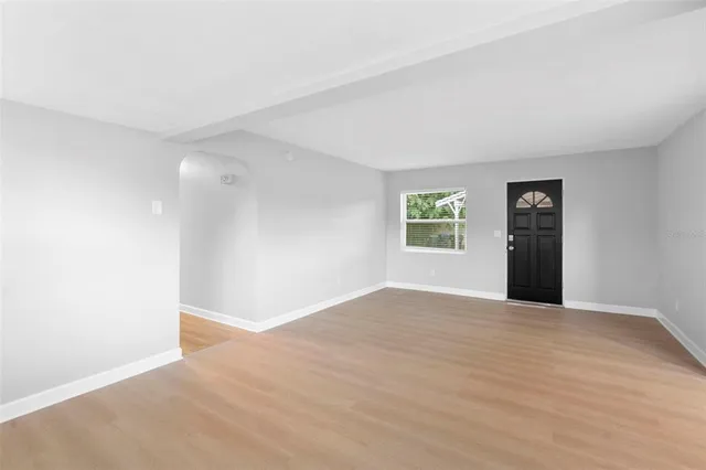 a large white kitchen with a stove a sink dishwasher and a refrigerator with wooden floor