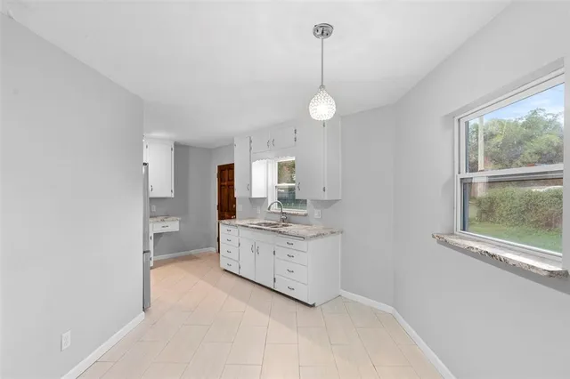a bathroom with a toilet a sink a vanity and a window