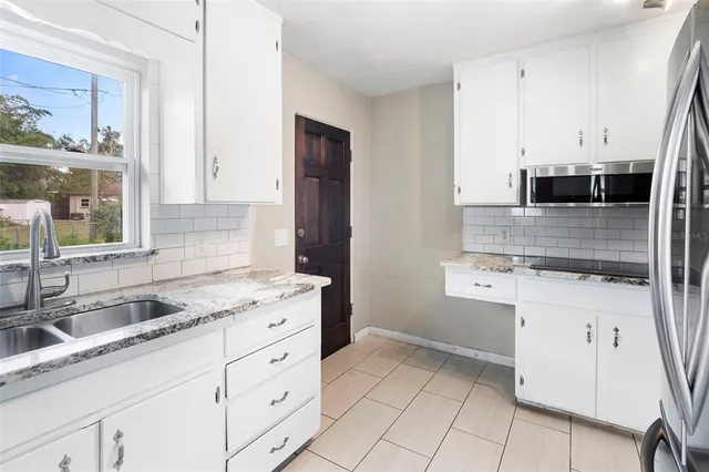 an empty room with a window and a ceiling fan