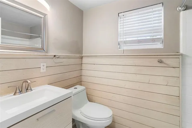 an empty room with a window and a ceiling fan