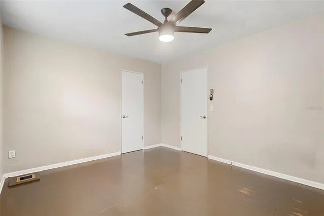 a view of an empty room with window and wooden floor
