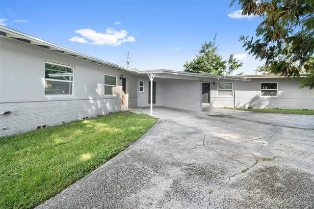 a view of a house with a yard and sitting area