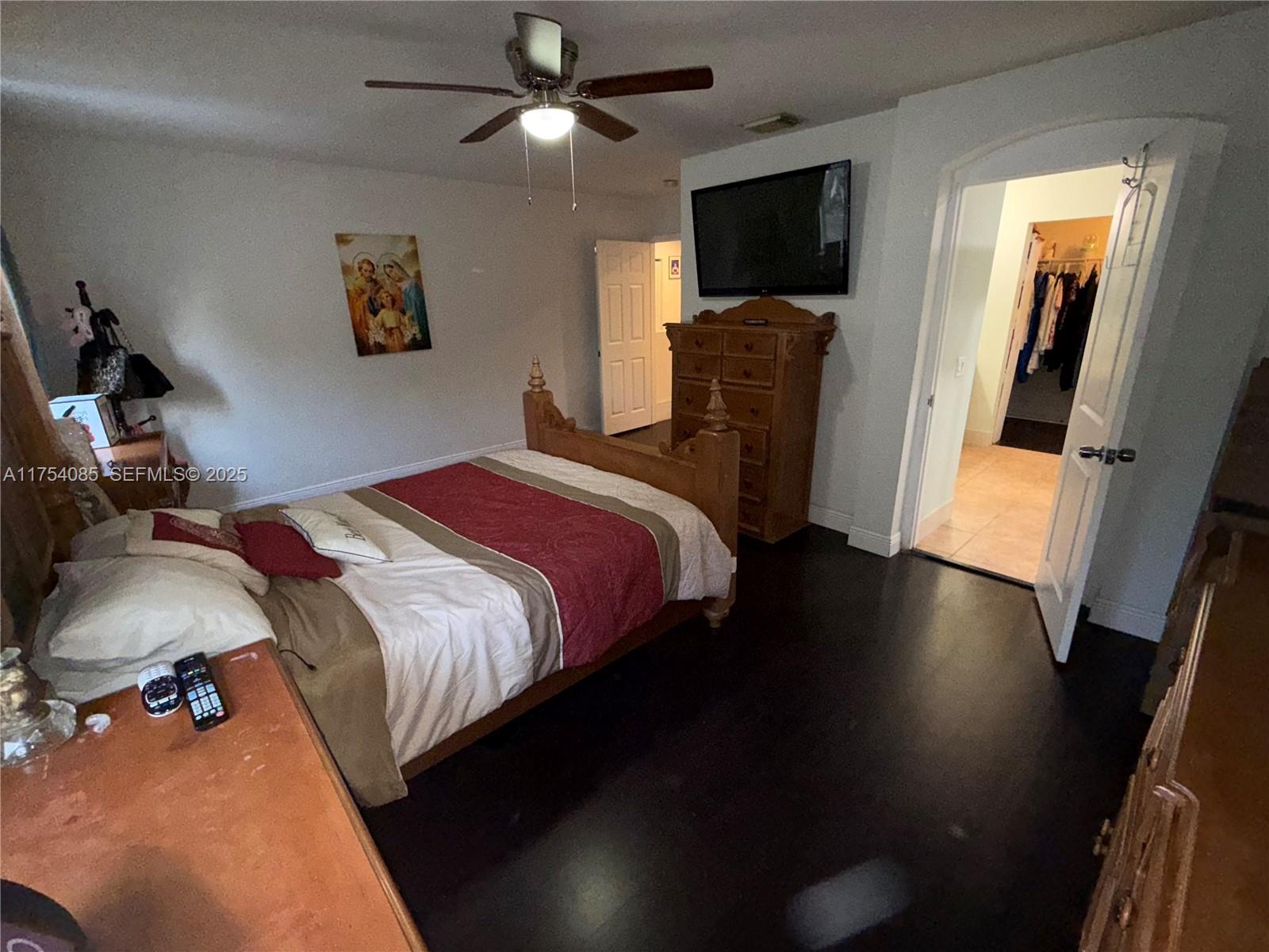 16618 Southwest 68th Terrace Miami, FL 33193 - Photo 18 of 34 a bedroom with a bed and a flat screen tv