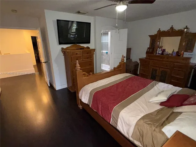 a bedroom with a bed dresser and a flat tv screen