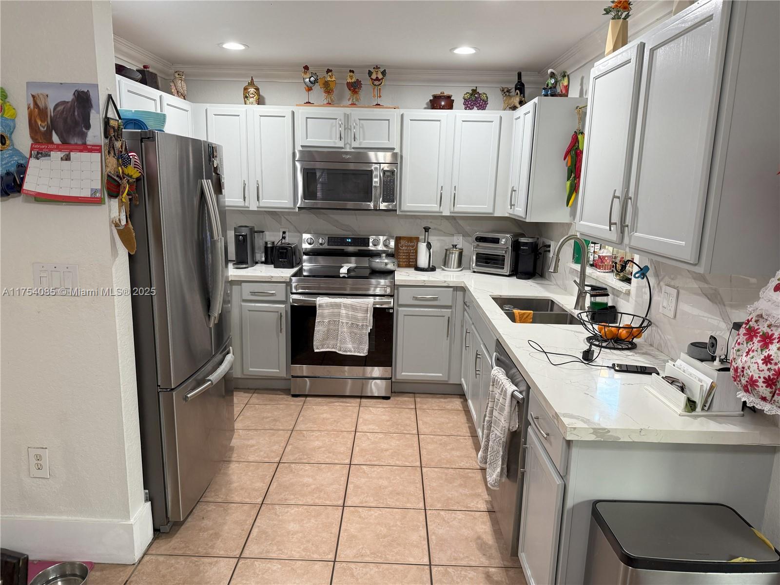 16618 Southwest 68th Terrace Miami, FL 33193 - Photo 29 of 34 a kitchen with stainless steel appliances a refrigerator sink and microwave