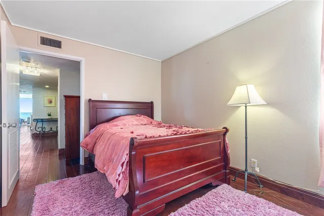 a large bedroom with a bed and wooden floor