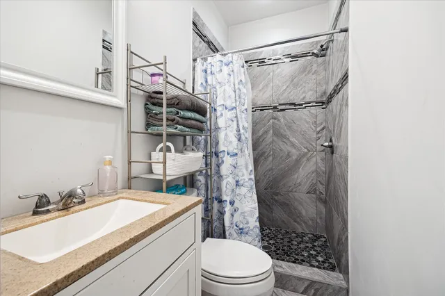 a bathroom with a sink toilet vanity and shower