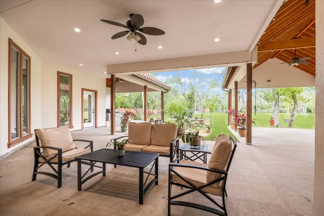 a dining room with furniture a rug and a floor to ceiling window