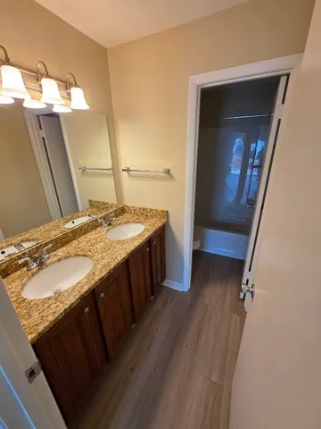 a spacious bathroom with a granite countertop sink a mirror and shower
