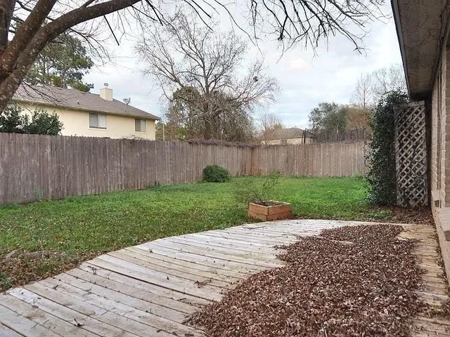a view of a backyard with wooden fence