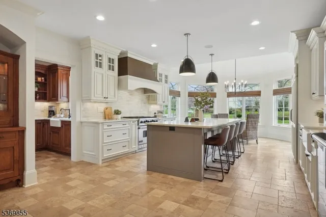 a kitchen with kitchen island granite countertop a sink stainless steel appliances and cabinets