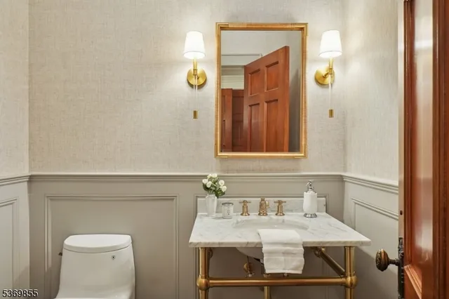 a bathroom with a double vanity sink mirror double shower and a toilet