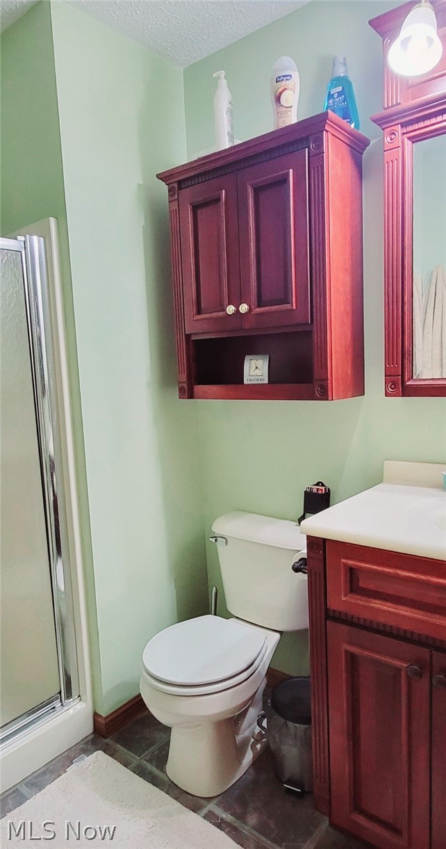 52675 North Ridge Road Vermilion, OH 44089 - Photo 19 of 42 Bathroom with a shower with door, tile patterned flooring, a textured ceiling, toilet, and vanity