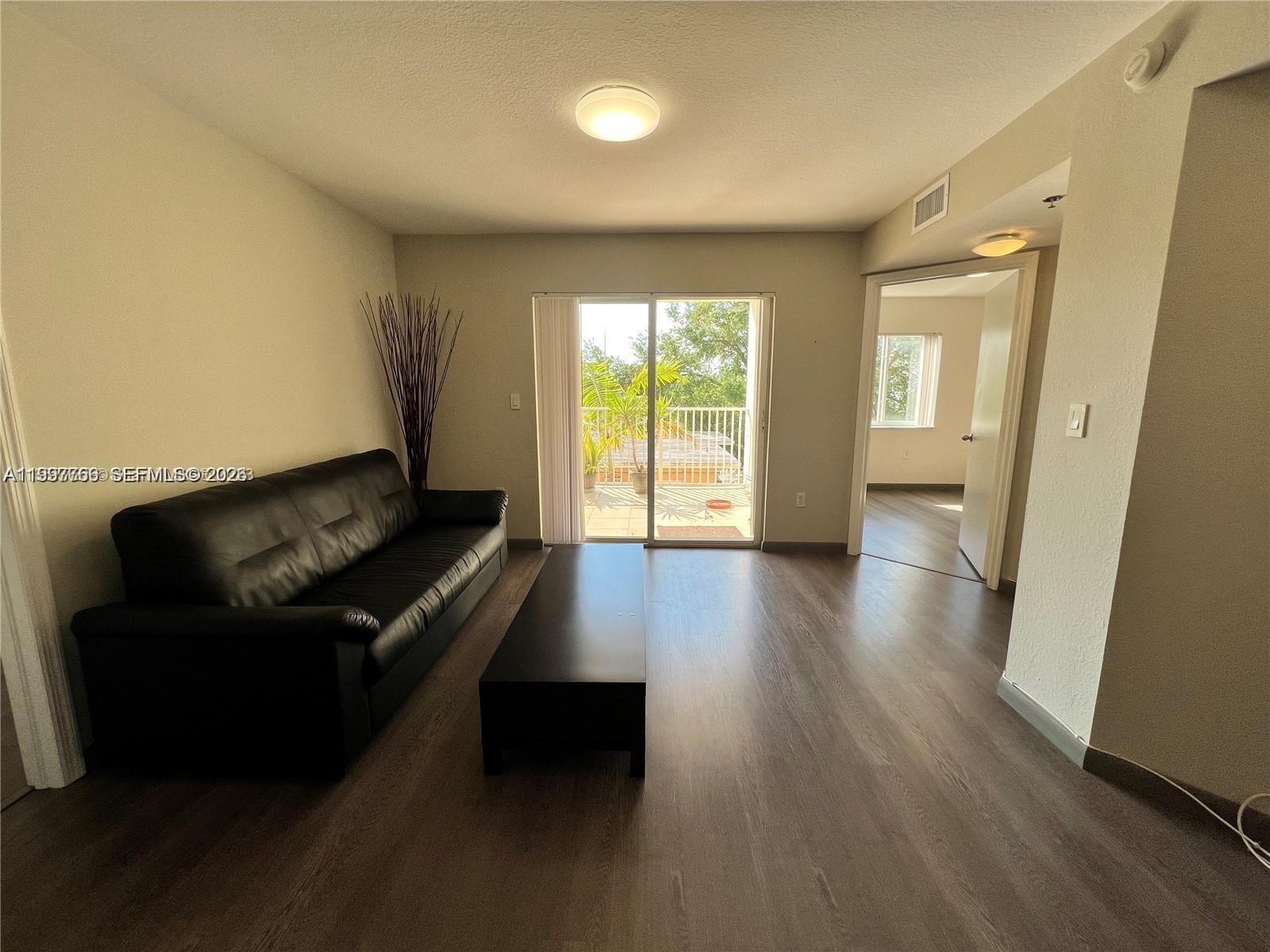 637 Southwest 3rd Street, Unit 306 Miami, FL 33130 - Photo 2 of 19 a living room with furniture and a wooden floor