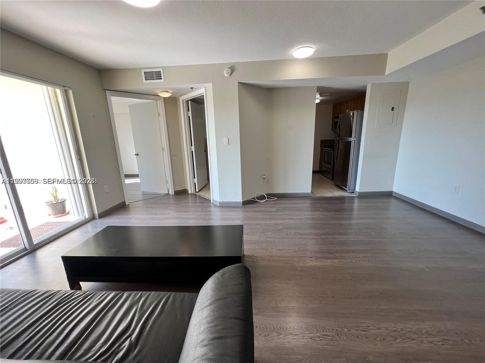637 Southwest 3rd Street, Unit 306 Miami, FL 33130 - Photo 4 of 19 wooden floor in an empty room with a window