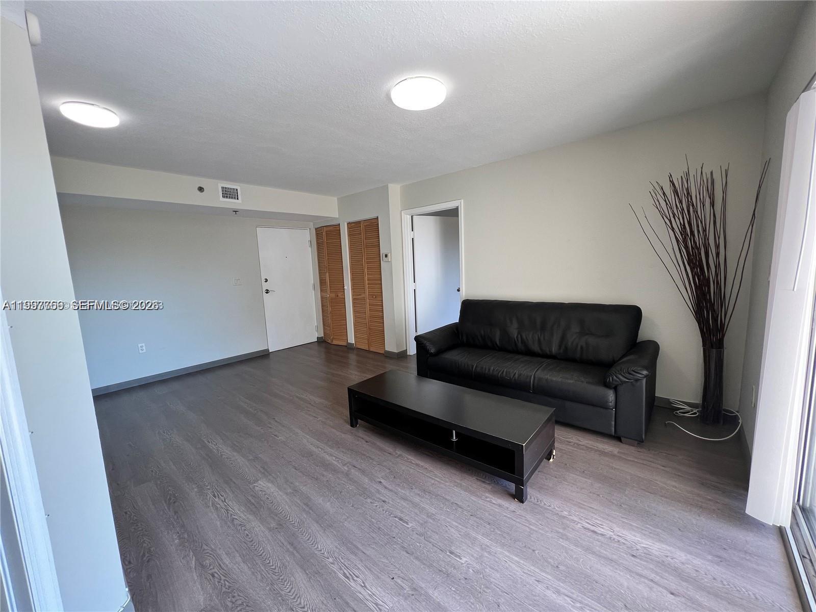 637 Southwest 3rd Street, Unit 306 Miami, FL 33130 - Photo 5 of 19 a living room with furniture and a wooden floor