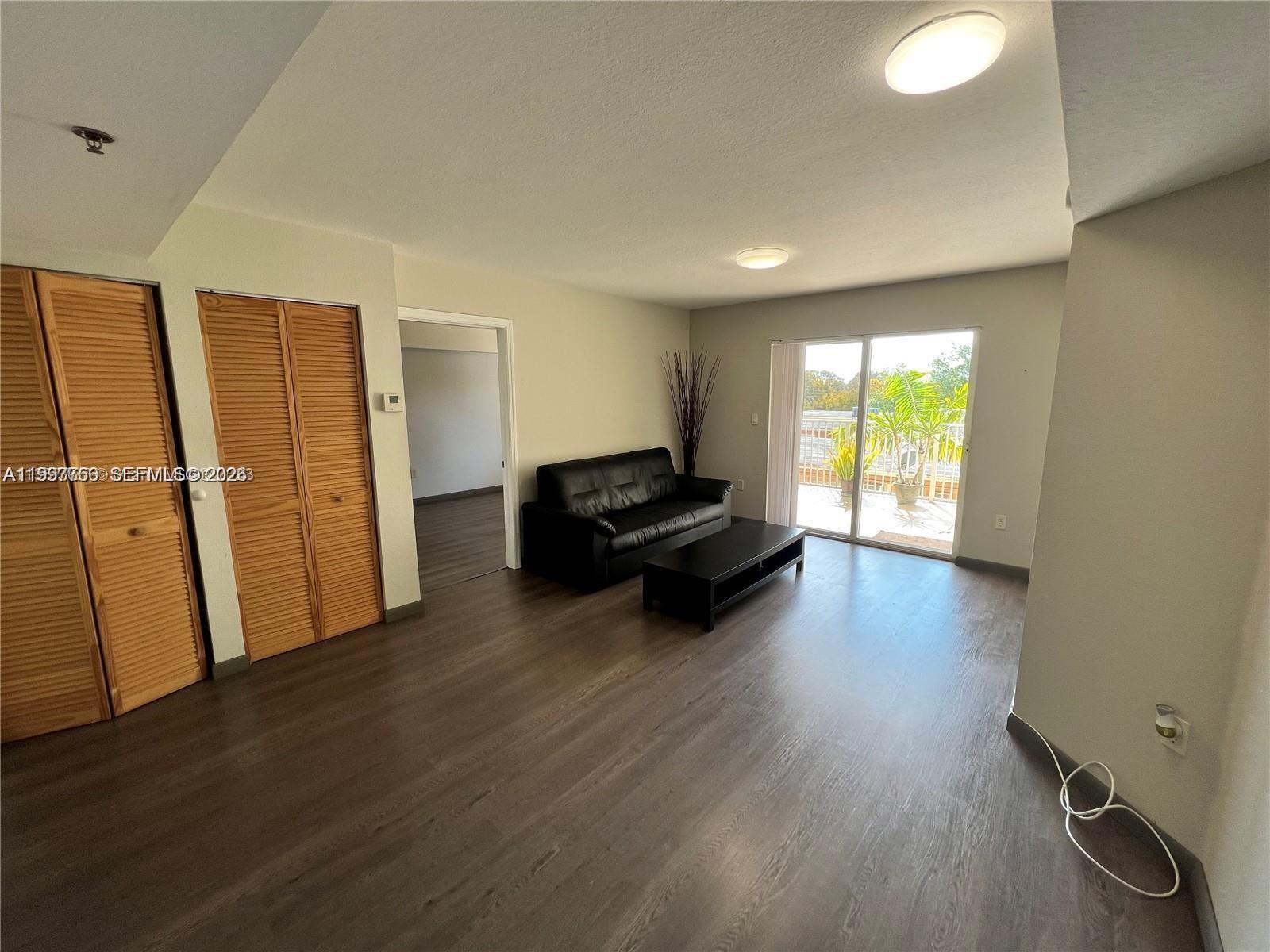 637 Southwest 3rd Street, Unit 306 Miami, FL 33130 - Photo 6 of 19 a living room with furniture and a wooden floor