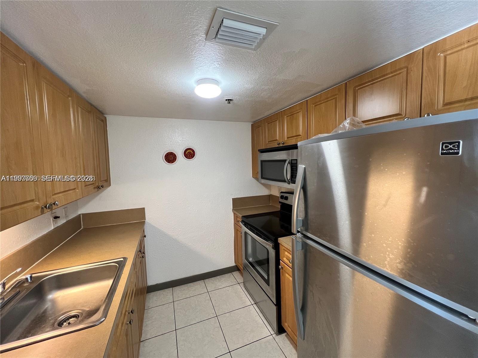 637 Southwest 3rd Street, Unit 306 Miami, FL 33130 - Photo 7 of 19 a kitchen with stainless steel appliances a refrigerator sink and microwave