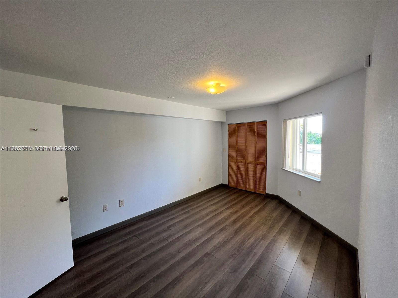 637 Southwest 3rd Street, Unit 306 Miami, FL 33130 - Photo 9 of 19 a view of an empty room with wooden floor and a window