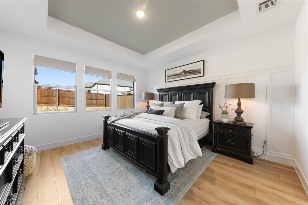 1340 Cartona Road Fate, TX 75087 - Photo 13 of 32 a bedroom with a bed and wooden floor