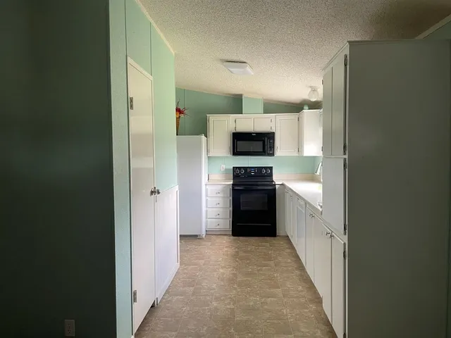 a kitchen with a refrigerator and a stove