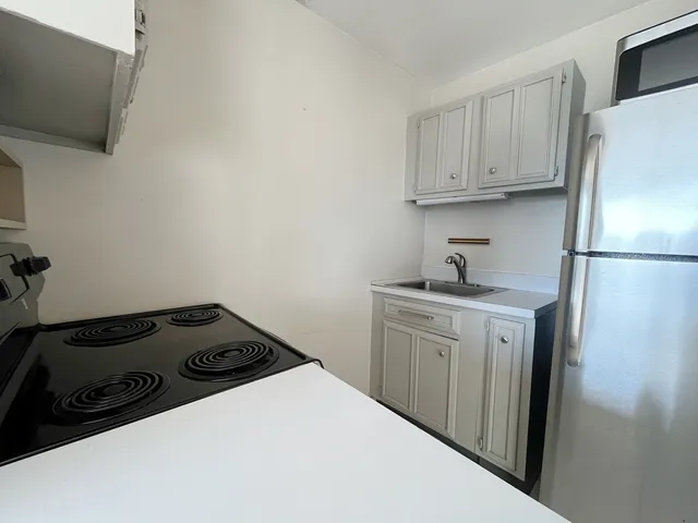 a kitchen with a refrigerator and a stove top oven
