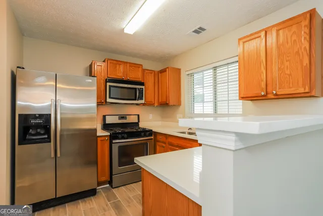 a kitchen with a sink stove top oven and cabinets