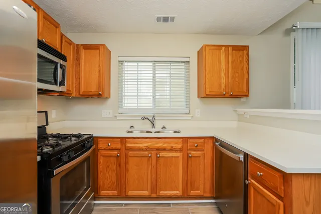 a kitchen with stainless steel appliances a stove a microwave and sink