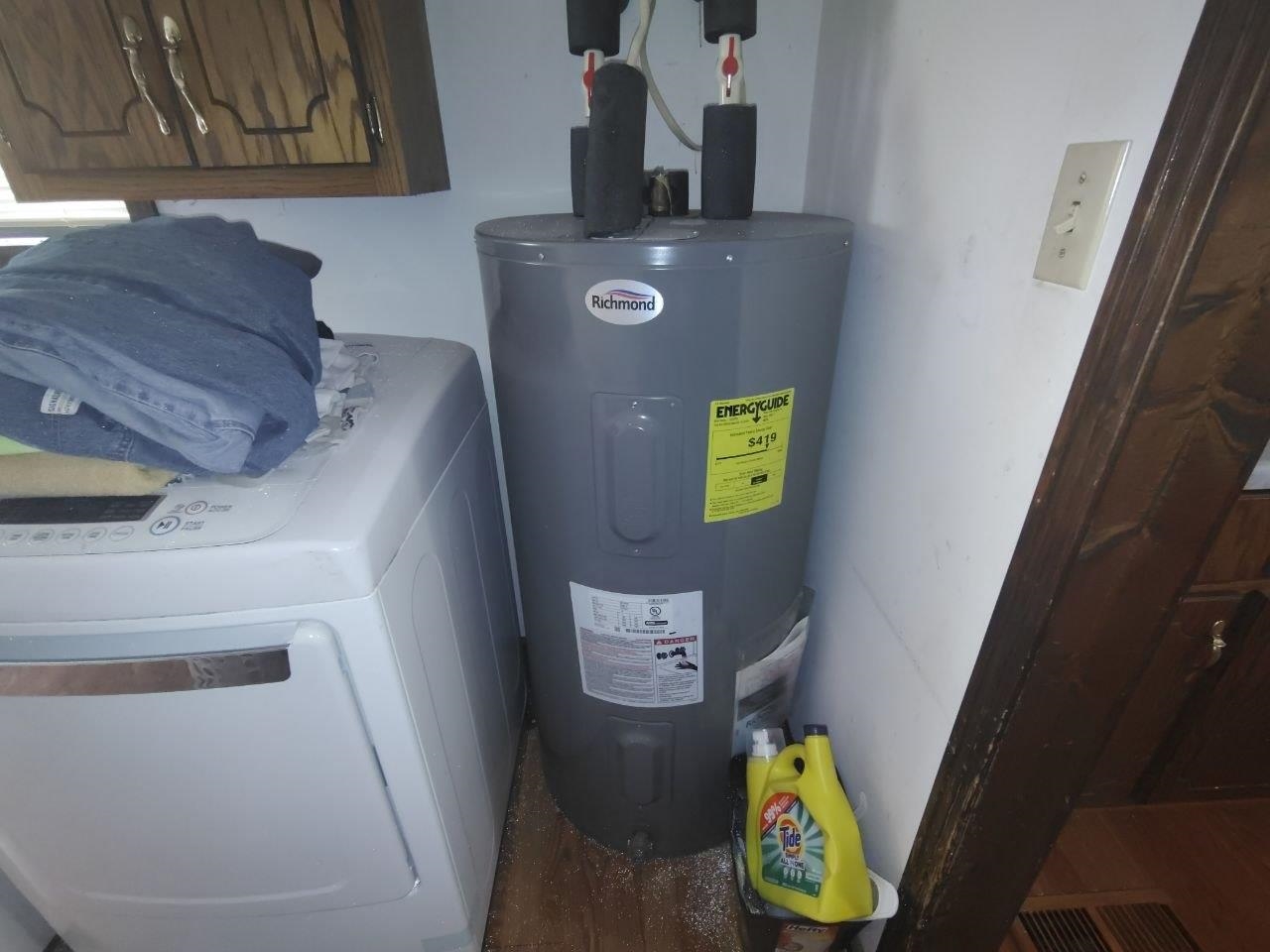 1475 Authur Byrd Road Pocahontas, TN 38061 - Photo 15 of 37 Dedicated utility area featuring a water heater, wood-finish flooring, and a wall-mounted light switch