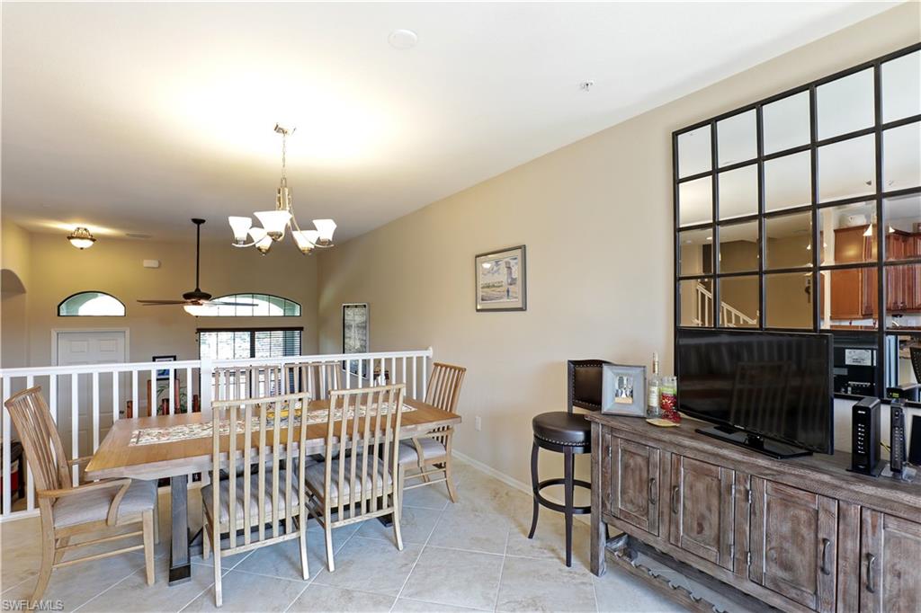 9051 Capistrano Street North, Unit 4308 Naples, FL 34113 - Photo 4 of 20 a view of a livingroom with furniture a fireplace a chandelier fan and wooden floor