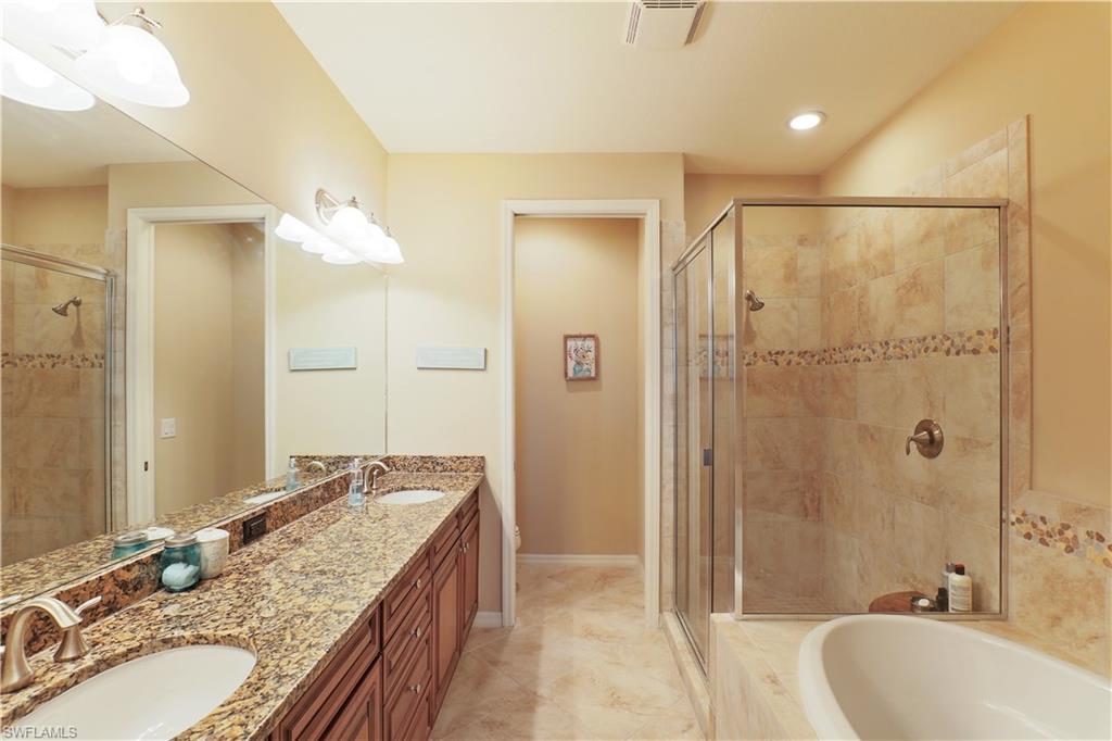 9051 Capistrano Street North, Unit 4308 Naples, FL 34113 - Photo 9 of 20 a bathroom with a granite countertop tub sink and shower