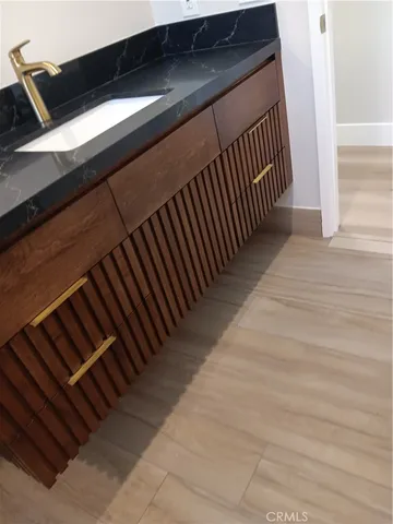 a bathroom with a granite countertop sink toilet and mirror
