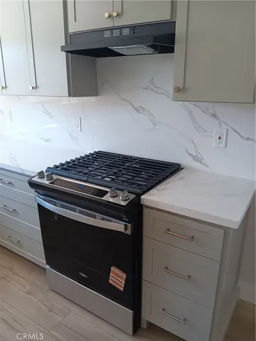 a stove top oven sitting inside of a kitchen