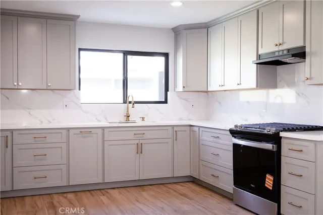 a kitchen with granite countertop white cabinets and a sink