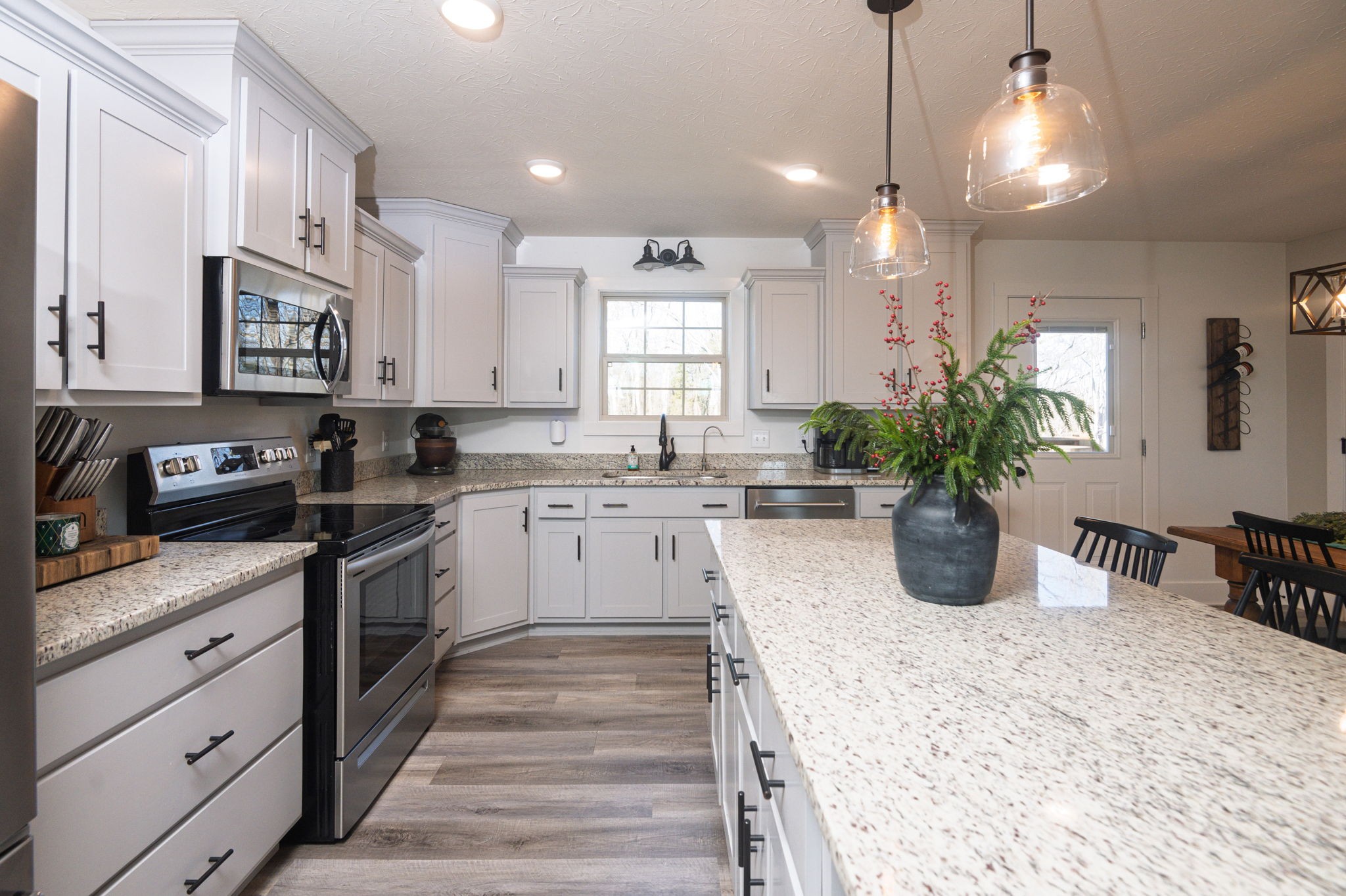 720 Armstrong Road Castalian Springs, TN 37031 - Photo 11 of 45 a kitchen with a white stove top oven and white cabinets with wooden floor