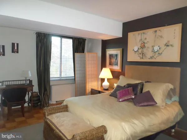 a bedroom with bed and wooden floor