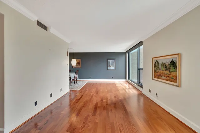 a view of empty room with wooden floor