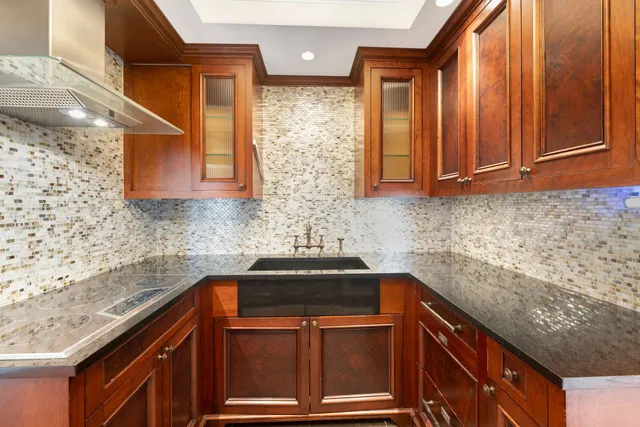a kitchen that has a sink stainless steel appliances wooden floor and glass door