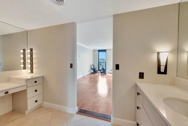 a large white kitchen with kitchen island a sink stainless steel appliances and cabinets