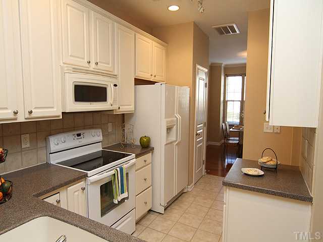 7843 Spungold Street Raleigh, NC 27617 - Photo 9 of 20 a kitchen with stainless steel appliances granite countertop a sink stove and refrigerator